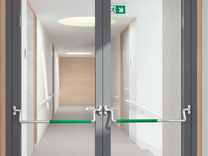Doppeltür aus Glas ausgestattet mit zwei Panikstangen aus Edelstahl mit grünem Griffrohr aus Polyamid